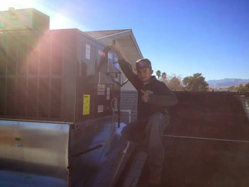 HVAC technician performing Air Duct Cleaning on a rooftop unit in Moorefield